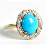 A yellow metal turquoise and diamond dress ring, the cabochon cut turquoise surrounded by a halo