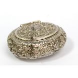 A white metal oval snuff box with chased foliate scroll decoration and vacant cartouche to hinged