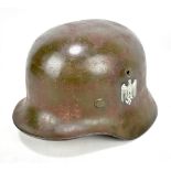 A German WWII German M40 model helmet with Normandy camouflage over paint liner and later decals.