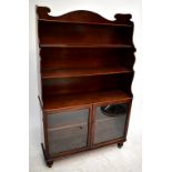 An Edwardian mahogany waterfall bookcase with three fixed shelves above two glazed doors, height