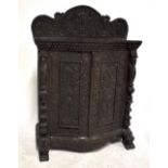 A late 19th century intricately carved Burmese side cabinet of serpentine outline, possibly