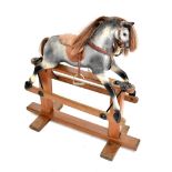 A 20th century grey painted rocking horse, raised on pine stand, height 95cm.