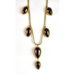 An unusual Victorian yellow metal and garnet set necklace, each drop with locket of hair to the