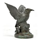 A bronzed figure depicting a bird perching in naturalistic setting, height 20cm.