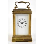 A circa 1900 miniature brass carriage clock, the white enamel dial set with Roman numerals and the