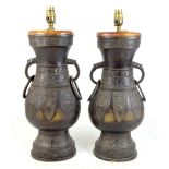 A pair of Chinese bronze vases of archaic form converted to lamps with elephant mask ring drop