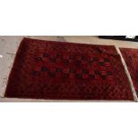 A Bokhara rug with central rectangular panel set with two rows of six medallions within a stylised