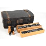 A pine casket containing two set of dominoes and a set of chess pieces with black knight repaired.