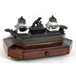 A Victorian desk stand of octagonal form, the upper bronzed metal section with two glass inkwells