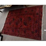 A red ground Bokhara rug with central rectangular panel set with three elephant foot medallions