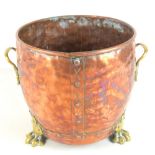 An early 20th century copper coal bucket with brass handles and paw feet.