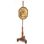 An early Victorian mahogany pole screen with needlework panel depicting a Scottish piper raised on