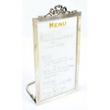 HAMILTON & CO; a George V hallmarked silver framed menu holder with applied cast ribbon, stamped ‘