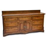 A George III oak dresser base with arrangement of seven drawers and pair of cupboard doors on
