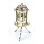 An early 20th century Dutch silver miniature bird in birdcage on circular three legged table, height