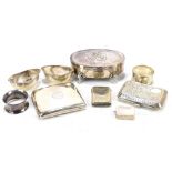 A group of silver items comprising two cigarette cases, two napkin rings, a pair of silver salts, an
