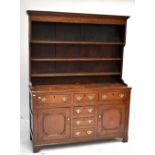 A 19th century oak dresser with plate rack back, with three drawers above two panelled cupboard
