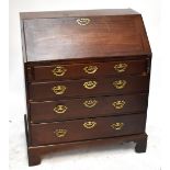 An early 19th century mahogany bureau, the fall-front enclosing fitted interior above four drawers