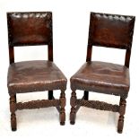 A set of four late Victorian oak and leather dining chairs with padded backs and seats, on turned