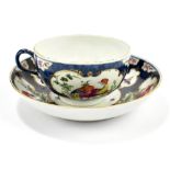 WORCESTER; an 18th century first period cup and saucer with blue scale ground and vignette panels