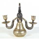 An Indian white metal bell shaped candle holder, with two branches with applied grapevine