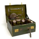 A George V green leather and silver mounted fitted travelling case, the tooled hinged lid set with