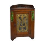 An Arts and Crafts oak hanging corner cabinet of small proportions inset with two oblong Art Nouveau