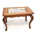 An early 20th century French oak coffee table, the rectangular top inset with six tiles and raised