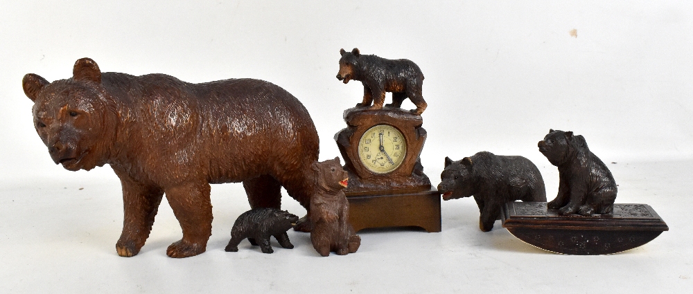 Six Black Forest carved wooden bears to include a figural clock, height 17cm, a desk blotter, etc (