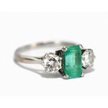 An 18ct white gold emerald and diamond three stone ring, the emerald cut emerald weighing approx 2.