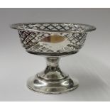 A George V hallmarked silver pierced dish on waisted stem to spreading circular foot,