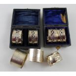 Two Edward VII hallmarked silver cased sets of two matching napkin rings, Ridley Brothers & Merton,