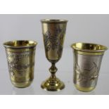 Two early 20th century Russian 84 Zolotnik silver tot cups with bright-cut floral decoration and