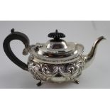 An Edward VII hallmarked silver bachelor's teapot with repoussé foliate scroll decoration and