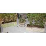 A pair of composite stone circular garden planters with pedestal bases in the Classical style,