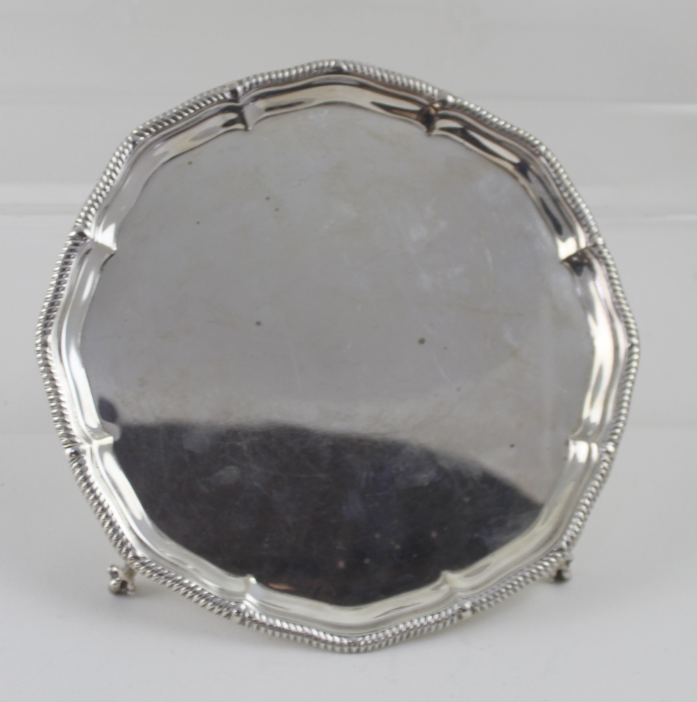 A George V hallmarked silver salver to four claw supports, diameter 20.