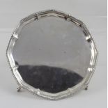 A George V hallmarked silver salver to four claw supports, diameter 20.