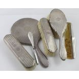 A hallmarked silver five-piece vanity set, hand mirror, ladies' brush,