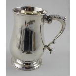 A Victorian hallmarked silver mug of baluster form with C-scroll handle on stepped circular