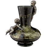 Ziervase "Putten"Um 1900. Vase aus grün marmoriertem Stein mit zwei Puttenfiguren aus versilbertem