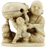 Netsuke FigurengruppeJapan um 1900. Maritimes Elfenbein. Der Glücksgott Hotei mit zwei Karakos