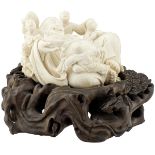 Kleine FigurengruppeChina um 1900. Elfenbein. Der Dickbauch-Buddha mit Silberbarren wird von vier