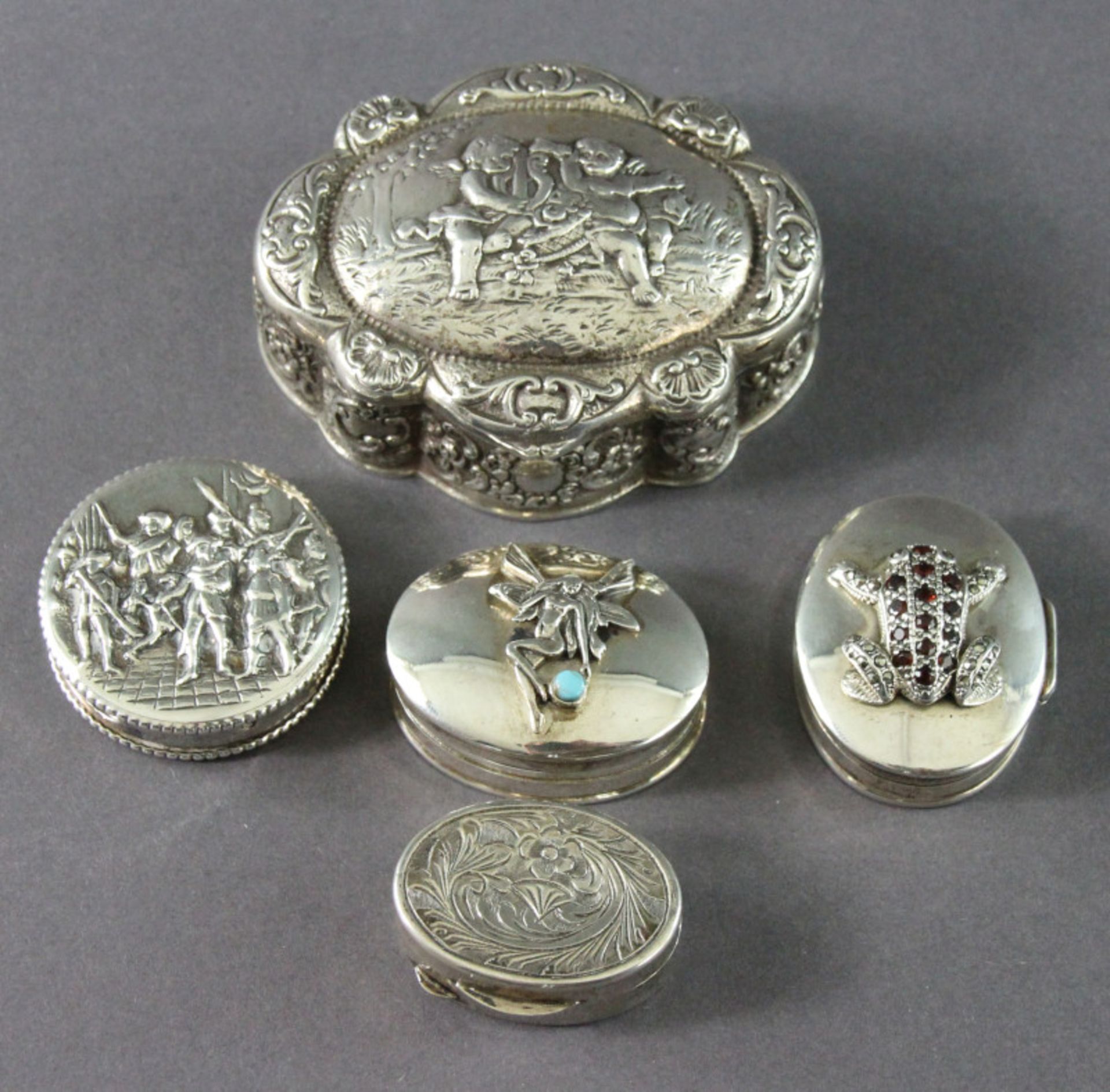 5 Pillendosen aus 800er, 830er und 925er Silber, 20. Jhd.Darstellungen mit Putten, Blumen, Tier