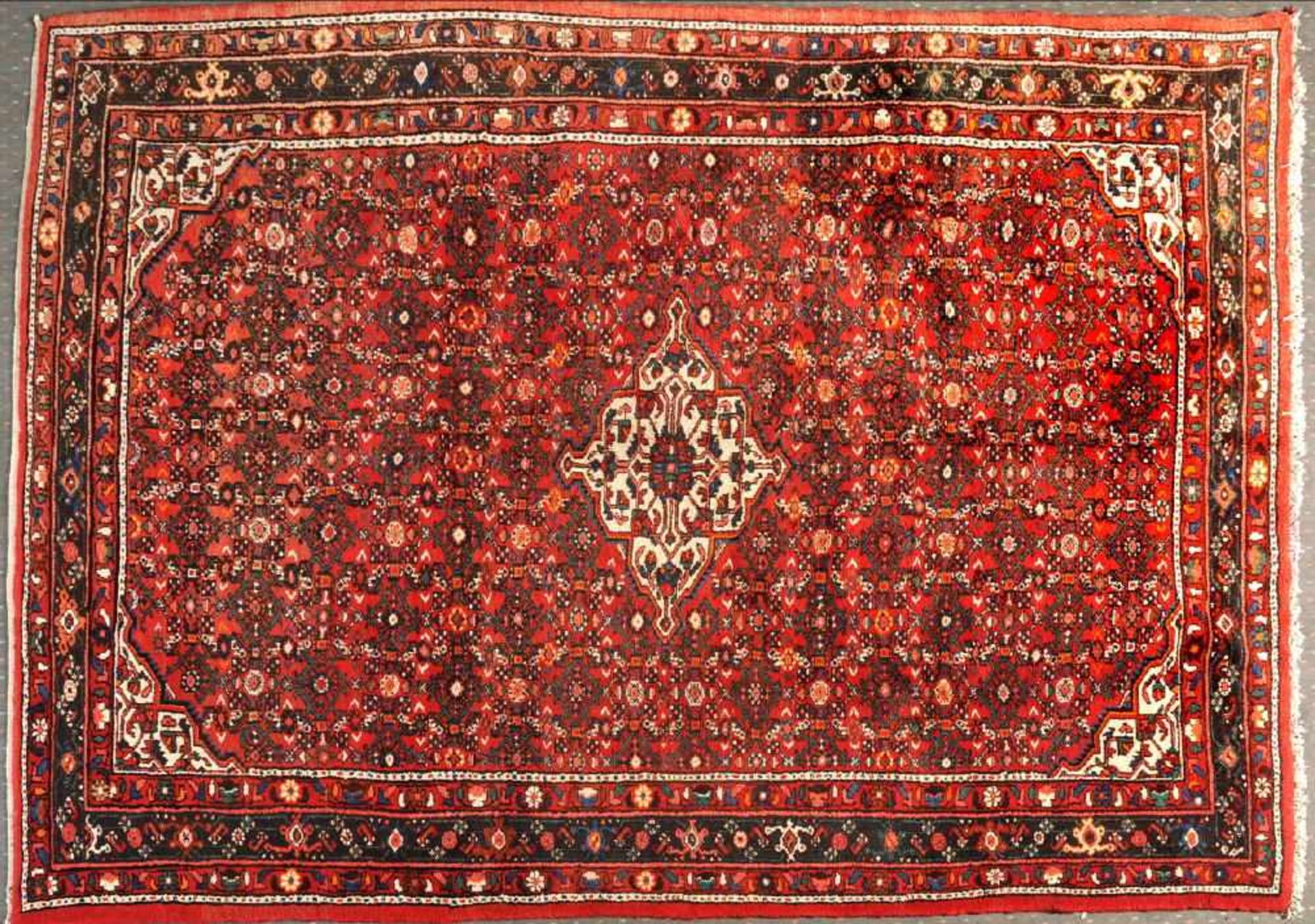 Ingelas, Persien, 218 x 312 cmälter, Wolle, rotgrundig, mehrfarb. Mittelstück, umgeben von stilis.
