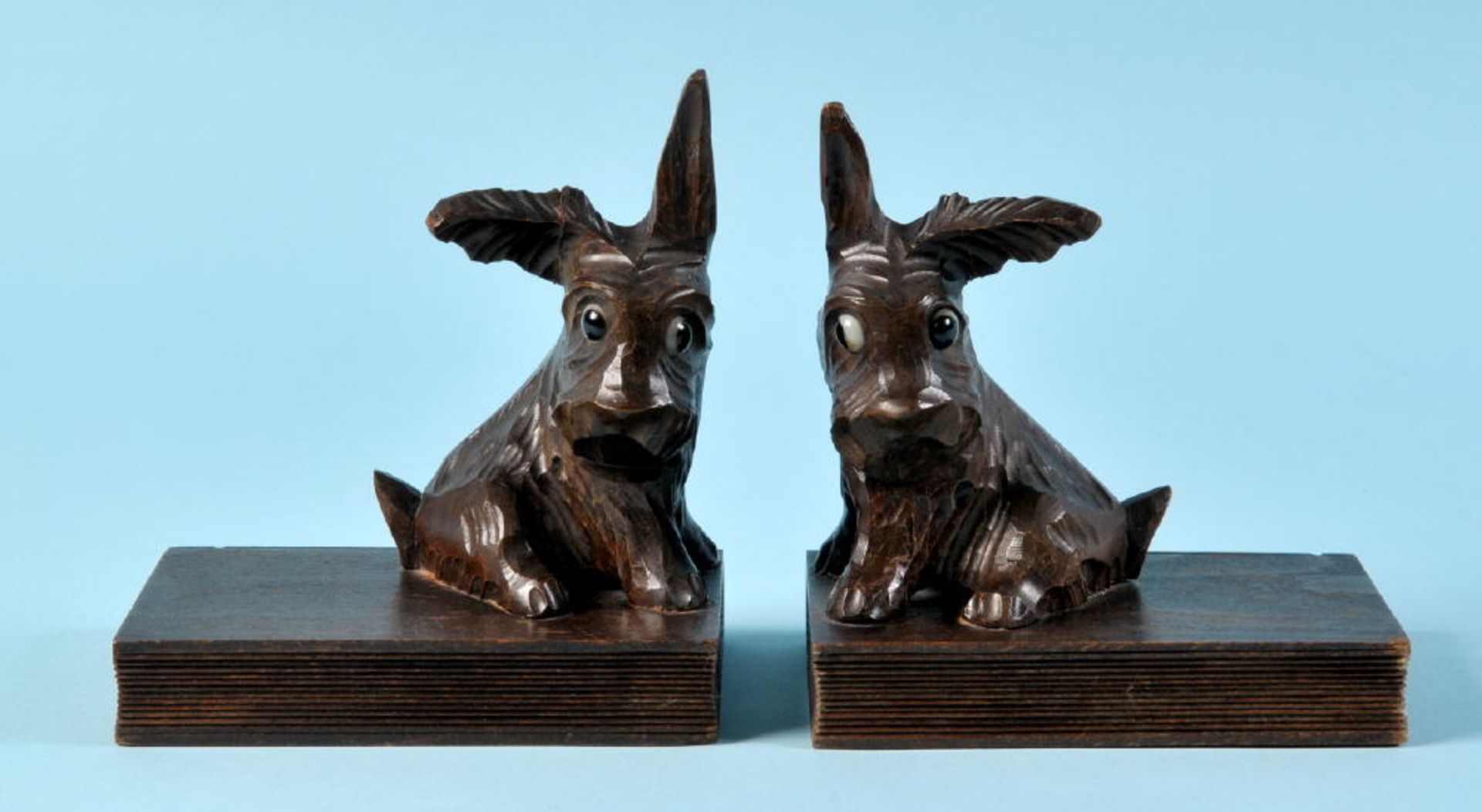 Buchstützen-PaarHolz, braun gebeizt, Form als Hunde (mit Glasaugen) auf Büchern, H= 16 cm