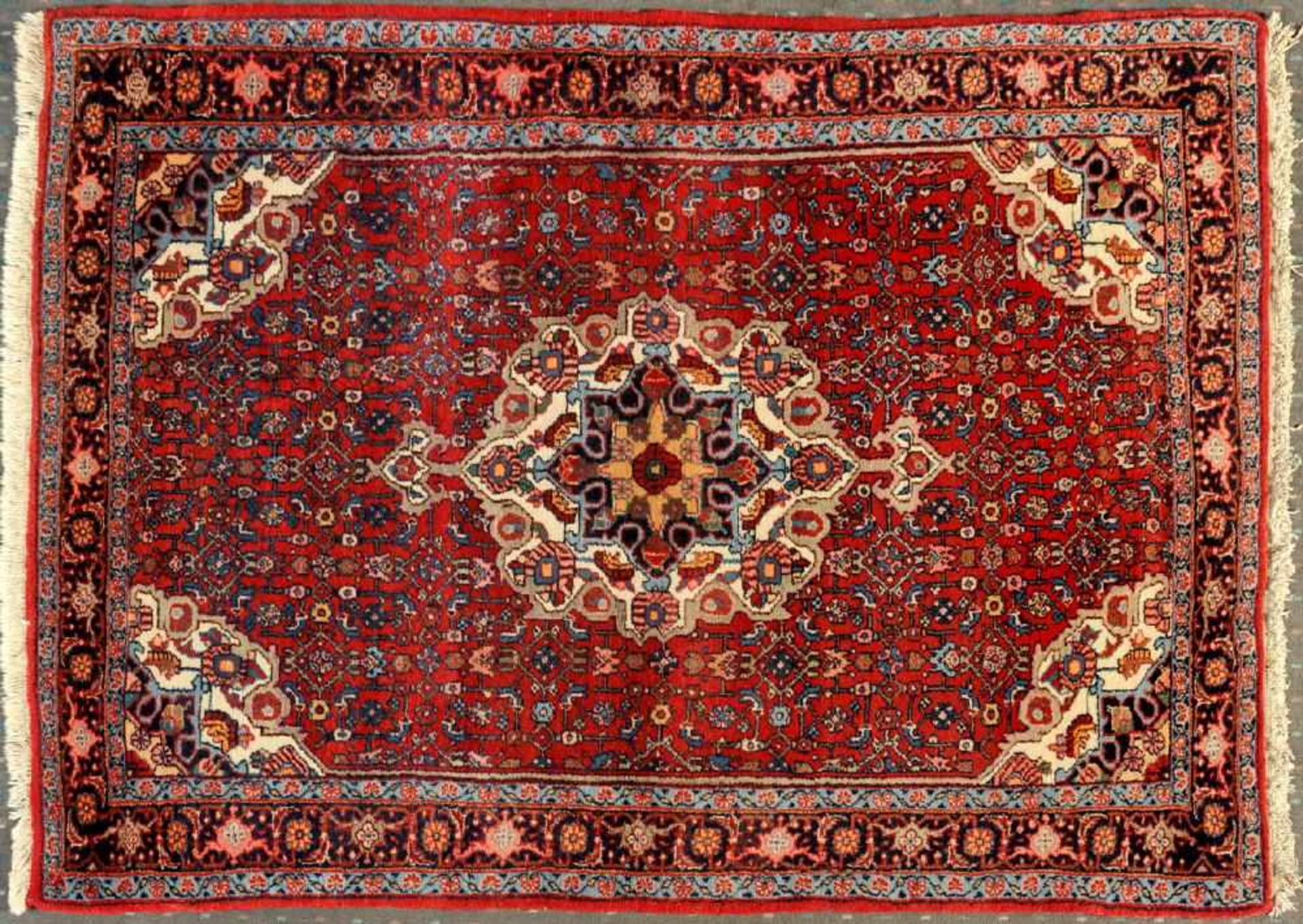 Bidjar, Persien, 111 x 175 cmWolle, rotgrundig, mehrfarb. Mittelstück, umgeben von floralen Motiven,