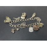 Vintage silver charm bracelet with nine silver charms. Fully hallmarked Birmingham 1964. 48 grams