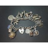 Vintage silver charm bracelet with 17 charms. Hallmarked from Birmingham 1975. 65g