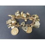 Large charm bracelet with 30 gold charms including 1x 1909 full sovereign and 1x 1910 half sovereign