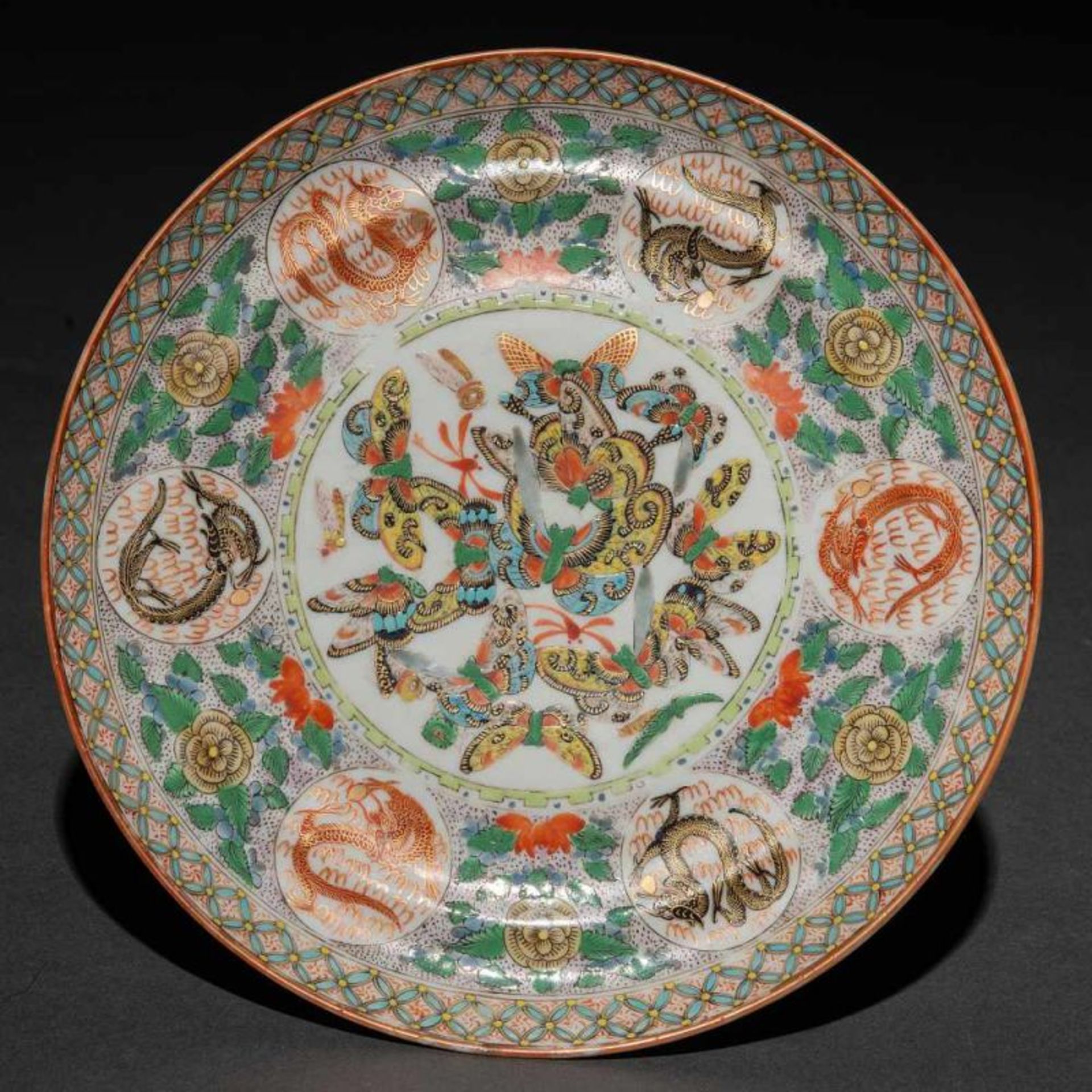 Plato circular en porcelana china. Trabajo Chino, Siglo XIXDecorado con mariposas y medallones con